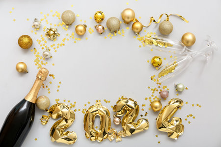 Frame made of figure 2024 with Christmas balls and champagne on white background