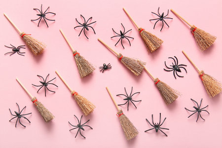 Halloween composition with brooms and spiders on pink backgroundの写真素材