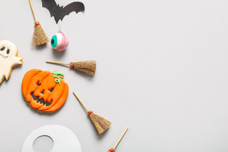 Halloween composition with brooms, pumpkin and eyeball on gray backgroundの写真素材