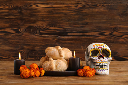 Bread of the dead with flowers, candles and painted skull on brown wooden background. Celebration of Mexico's Day of the Dead (El Dia de Muertos)の写真素材