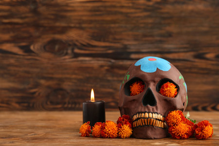 Marigold flowers with candle and painted skull on brown wooden background. Celebration of Mexico's Day of the Dead (El Dia de Muertos)の写真素材