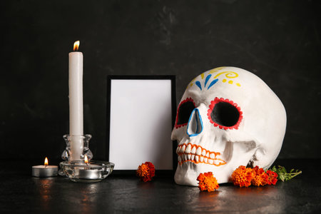 Marigold flowers with candles, painted skull and frame on black background. Celebration of Mexico's...