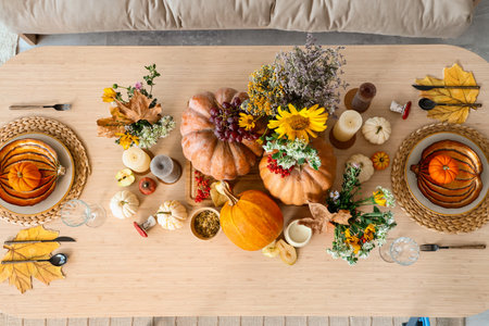 Autumn setting with pumpkins and flowers on dining table in room, top viewの写真素材