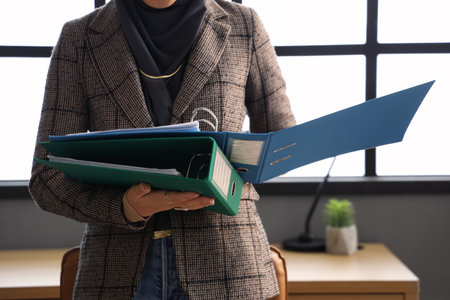 Young Muslim businesswoman with document folders in office, closeupの写真素材