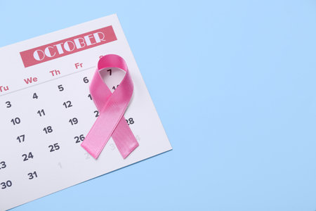 Pink ribbon with calendar on blue background. Breast cancer awareness conceptの写真素材