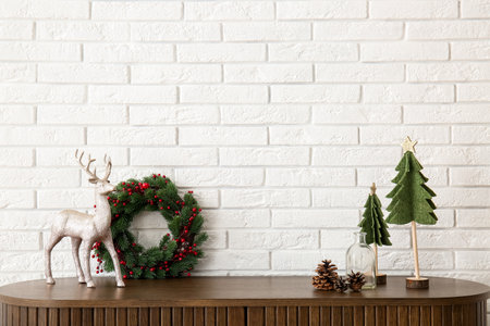 Wooden cabinet with Christmas decor and deer near white brick wallの写真素材
