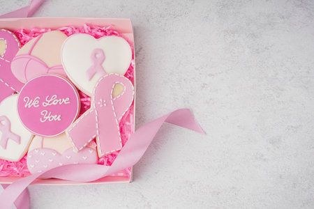 Box with pink cookies and ribbon on white grunge background. Breast cancer awareness conceptの写真素材
