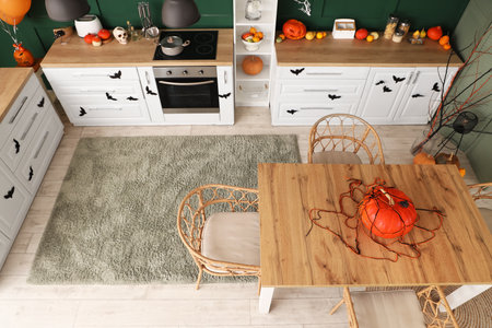 Interior of kitchen decorated for Halloween with white counters and dining table, top viewの写真素材