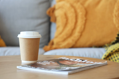 Cup of coffee with magazine on table in living room, closeupの写真素材