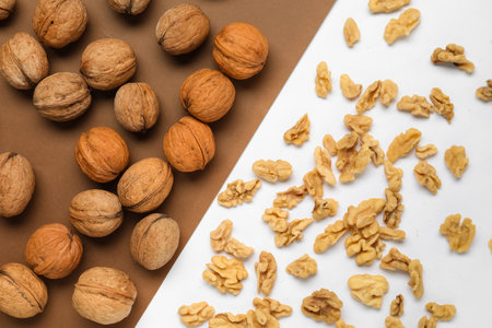 Whole and shelled walnuts on color backgroundの写真素材