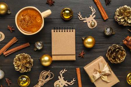 Blank paper calendar, gift box, cup of coffee and Christmas decorations on black wooden backgroundの写真素材