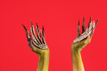 Witch with skeleton hands on red background. Halloween celebrationの写真素材