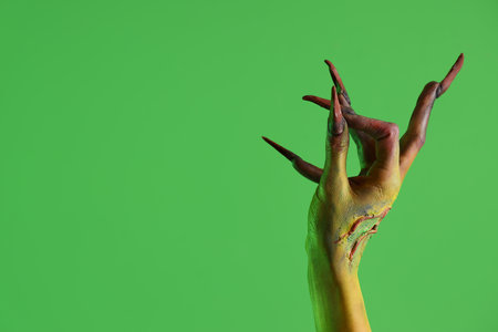 Witch with claws showing OK on green background. Halloween celebrationの写真素材