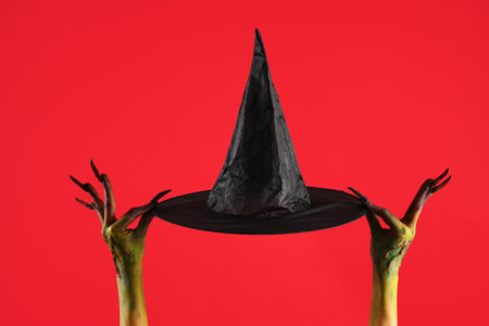 Witch with hat on red background. Halloween celebrationの写真素材