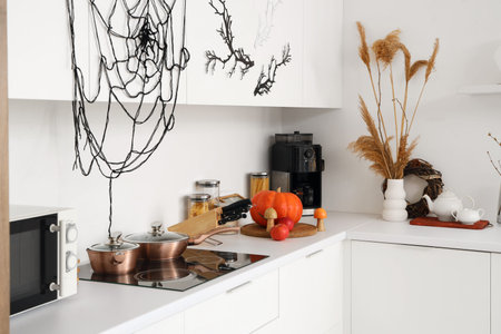 Interior of light kitchen decorated for Halloween with white counters