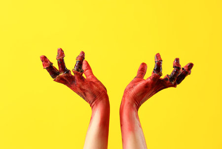 Bloodstained zombie hands on yellow background. Halloween celebrationの写真素材