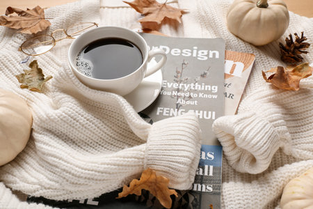 Composition with cup of coffee, magazines, knitted sweater and autumn decor, closeup