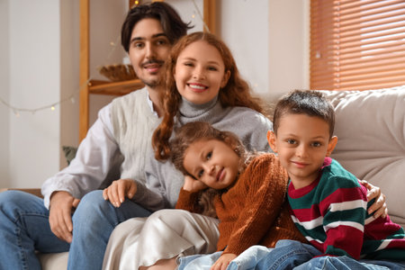 Happy family in warm sweaters at homeの写真素材