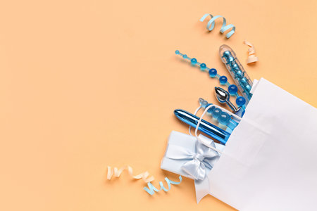 White shopping bag with sex toys and ribbons on beige backgroundの写真素材
