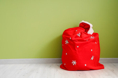 Santa bag of gifts near green wall in roomの写真素材