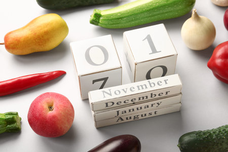 Fresh vegetables, fruits and cube calendar with date NOVEMBER 1 on gray background. World Vegan Day...