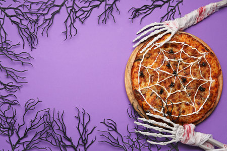 Frame made of wooden board with tasty pizza and decorations for Halloween party on purple backgroundの写真素材