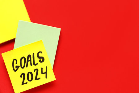 Sticky notes with goals for 2024 on red backgroundの写真素材