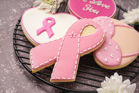 Cookies with pink ribbons on gray grunge background, closeup. Breast cancer awareness conceptの写真素材