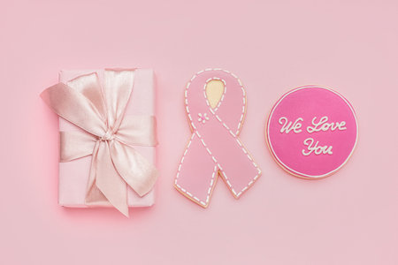 Gift box, cookies with ribbon and text WE LOVE YOU on pink background. Breast cancer awareness conceptの写真素材