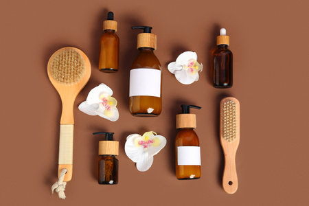 Composition with cosmetic products, massage brushes and orchid flowers on color backgroundの写真素材