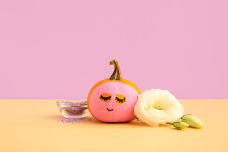 Pumpkin with mask, flower and sea salt on table against lilac backgroundの写真素材