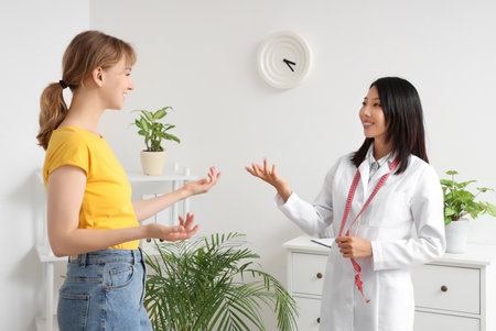 Female Asian nutritionist working with patient in officeの写真素材