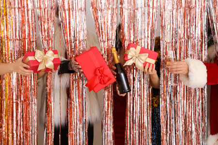 Group of young friends with gifts and champagne at Christmas partyの写真素材
