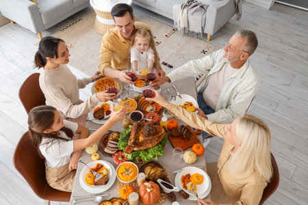 Happy family having dinner at festive table on Thanksgiving Dayの写真素材