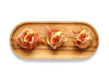 Wooden board with tasty sandwiches with prosciutto and figs on white backgroundの写真素材