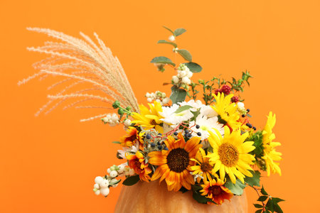 Beautiful autumn bouquet in pumpkin on orange backgroundの写真素材