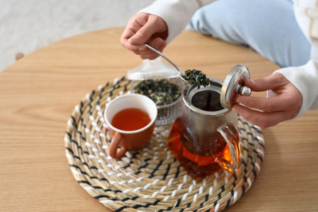 Young woman brewing tea at home, closeupの写真素材