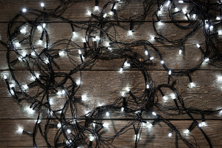 Christmas lights on dark wooden background