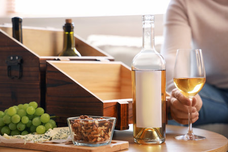 Young man with wine and snacks on table at home, closeupの写真素材