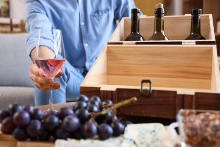 Young man with glass of pink wine at home, closeupの写真素材