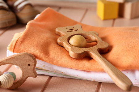 Stack of baby clothes and toys on color wooden table, closeupの写真素材