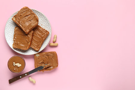 Plate of toasts with peanut butter and nuts on pink backgroundの写真素材