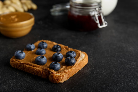Toast with peanut butter and blueberries on black backgroundの写真素材