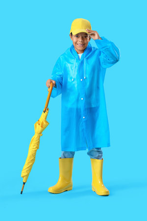 African-American little boy with umbrella on blue backgroundの写真素材