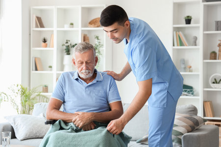 Male nurse with senior man in wheelchair at homeの写真素材
