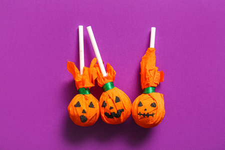 Sweet lollipops for Halloween party on purple backgroundの写真素材