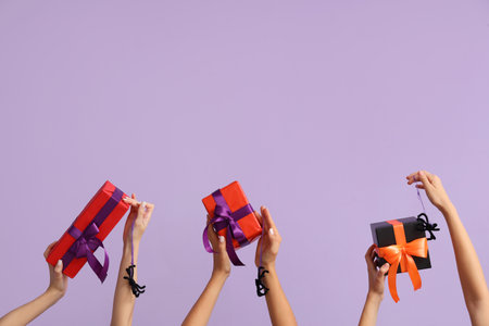 Women with Halloween gifts and spiders on lilac backgroundの写真素材