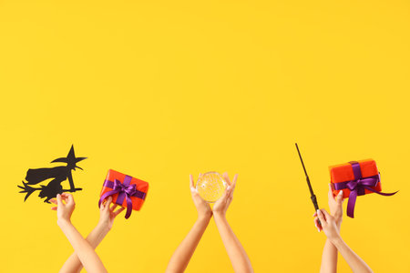 Women with Halloween gifts and decor on yellow backgroundの写真素材