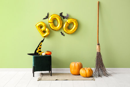 Word BOO made of balloons with paper bats on green wall in room interiorの写真素材