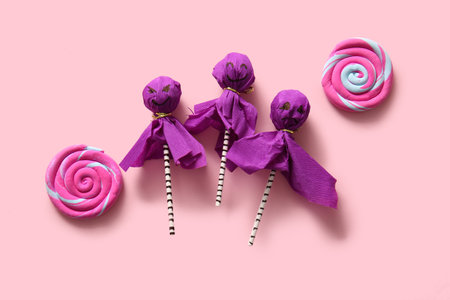 Sweet lollipops and candies for Halloween party on pink backgroundの写真素材